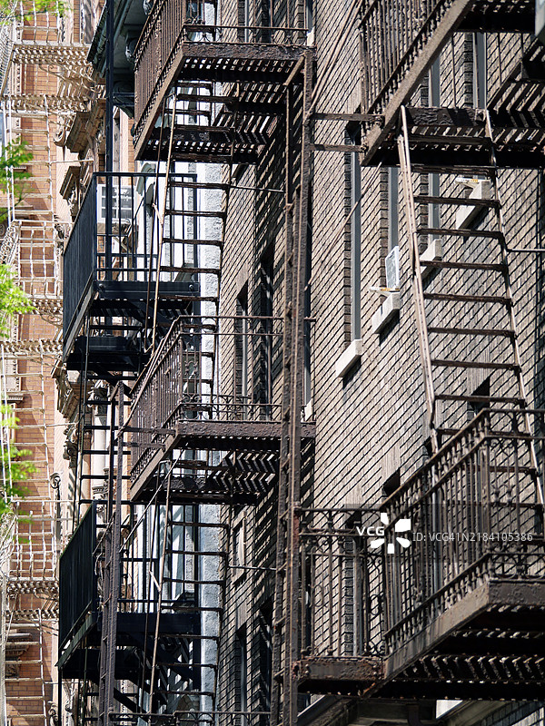 曼哈顿住宅建筑外立面上风化的金属消防梯特写，纽约州，美国。阳光。自然色彩。图片素材