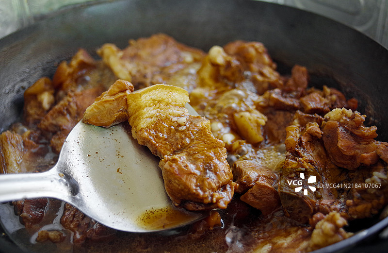 用铲子将泰式红烧肉（Palo）从锅中舀出。图片素材