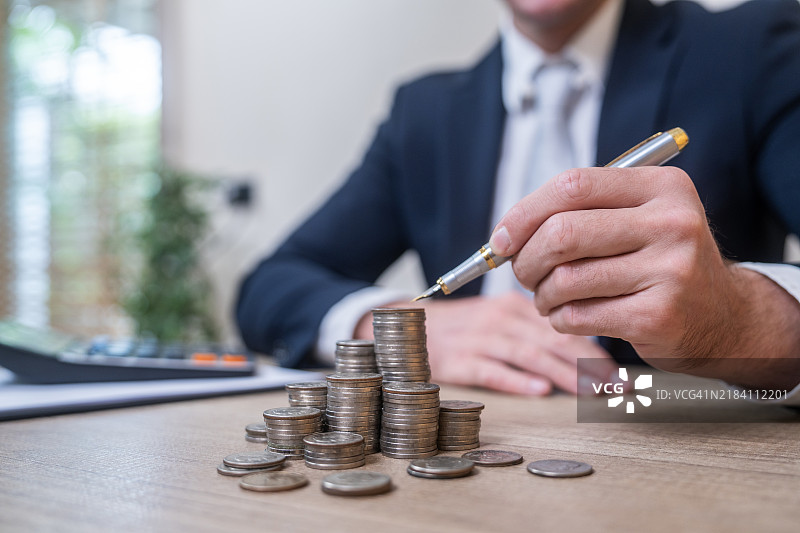 商人堆叠硬币：财务增长与战略的概念图片素材