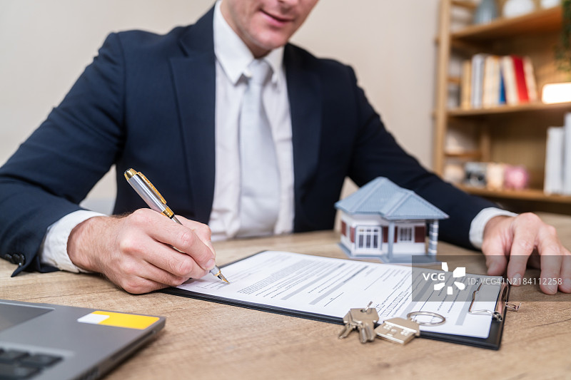 房地产经纪人在办公室签署物业文件图片素材