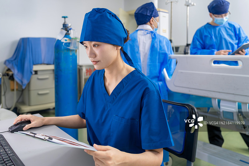 亚洲女性护士在胃镜室使用电脑查看治疗方案。图片素材