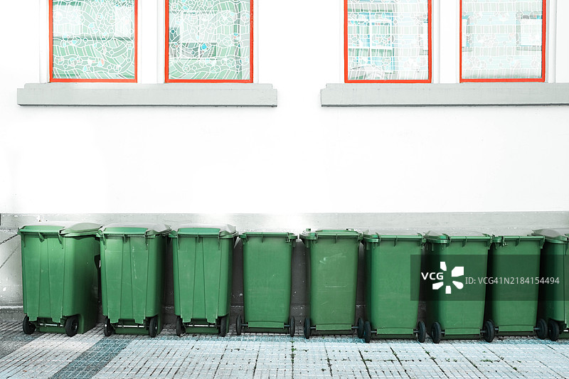 建筑外立面前排放的垃圾容器正面视图图片素材