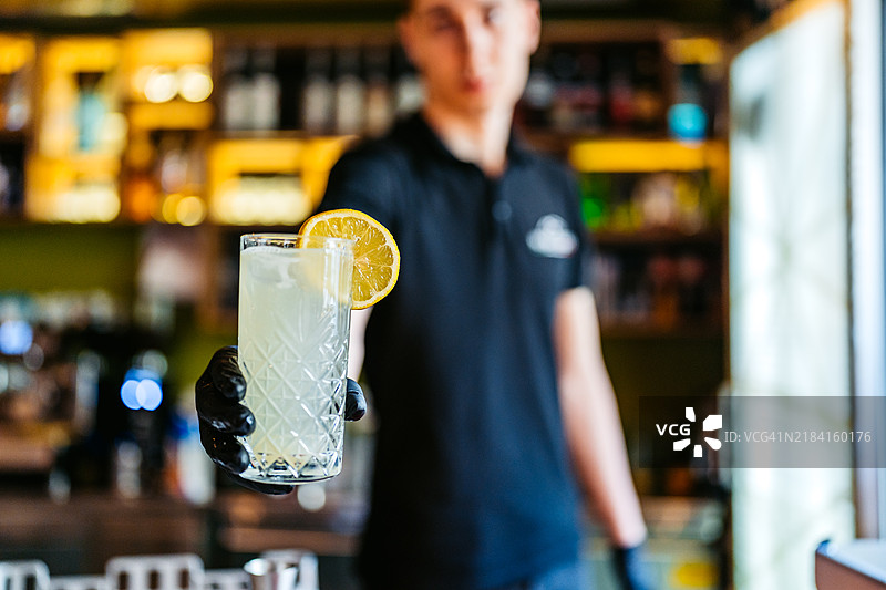 酒保在酒吧柜台上提供柠檬水图片素材
