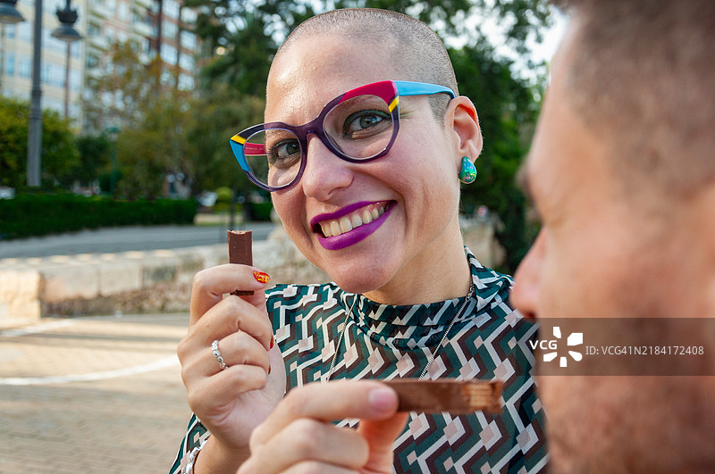 与朋友在户外分享的灿烂微笑和巧克力时刻图片素材