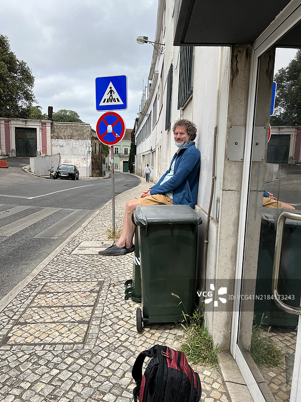 坐在里斯本垃圾箱上的男人图片素材
