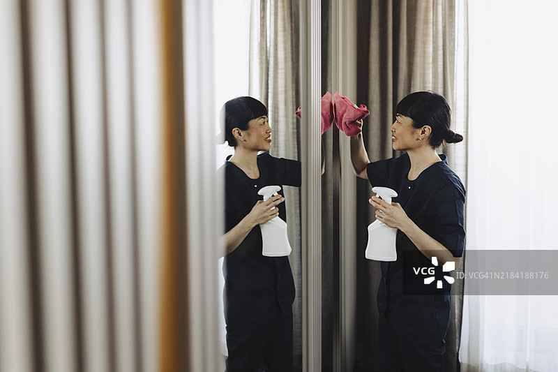 酒店女佣在房间内清洁镜子图片素材