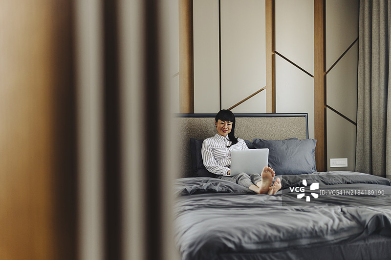 女商人在酒店房间使用笔记本电脑图片素材