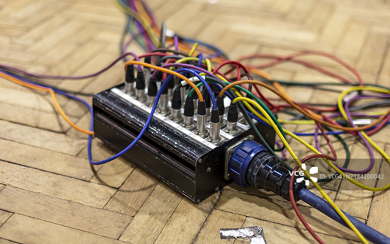一个复杂电子设备的特写，彩色电线散落在木地板上图片素材