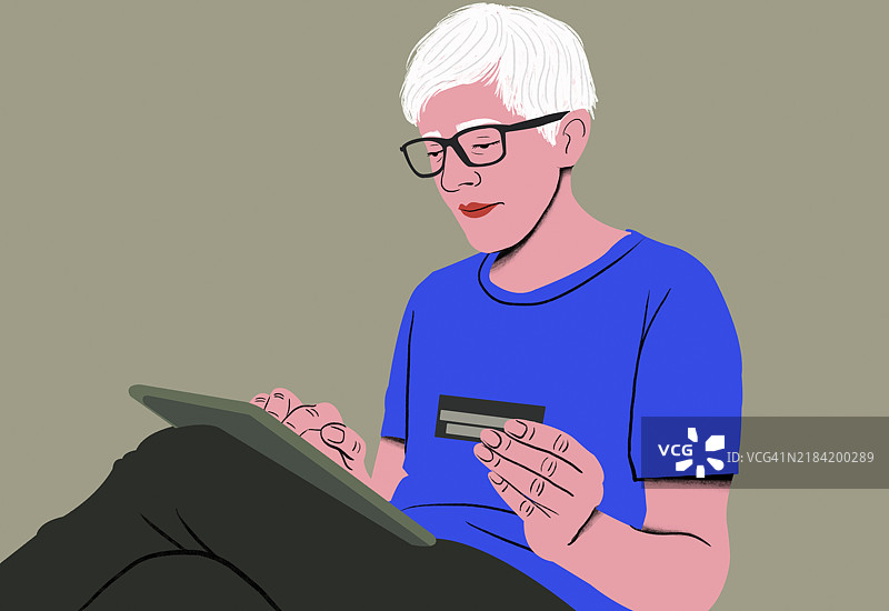 白发成年人使用平板电脑在线购物并持有信用卡图片素材