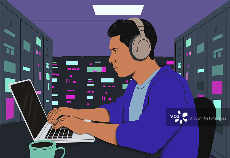 夜晚在色彩缤纷的办公室里，侧面特写一位专注的男士戴着耳机，正在使用笔记本电脑。图片素材