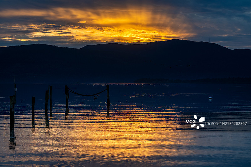 华盛顿州西部萨利什海地区的奥卡斯岛和罗萨里奥海峡上空的辉煌日落。图片素材