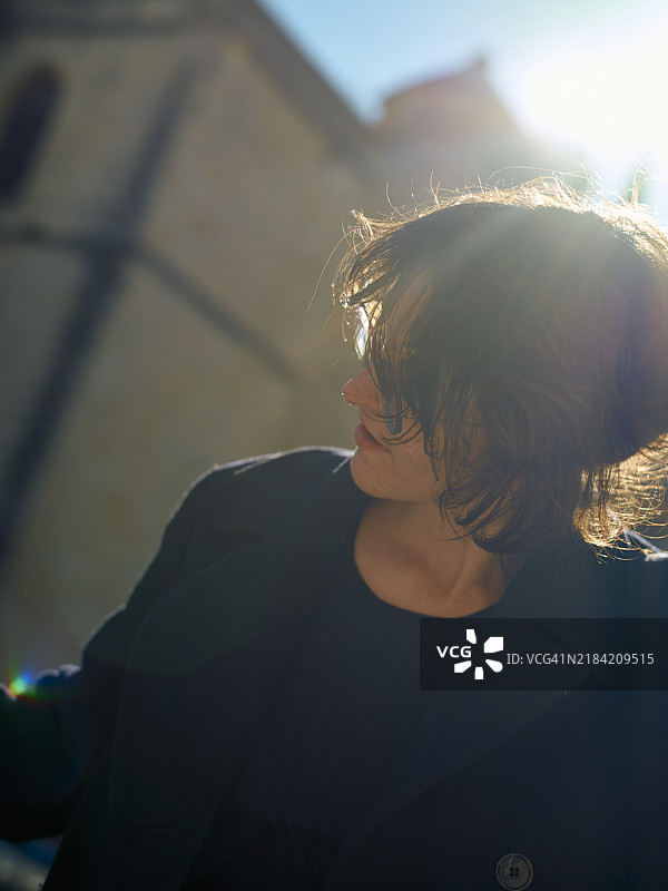 户外短发人物的逆光肖像，阳光光晕增强了场景的温暖色调图片素材