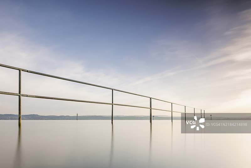 在温和的天空和宁静的水面前的栏杆，利多，利策尔斯特滕，博登湖，巴登-符腾堡州，德国，欧洲图片素材