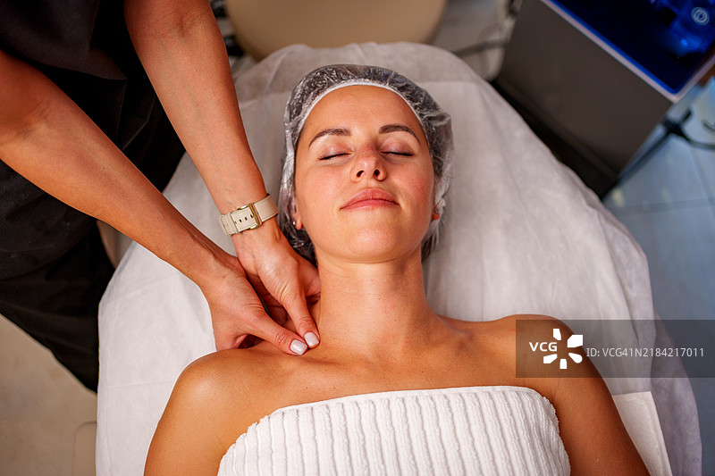 女性在美容院接受颈部按摩图片素材