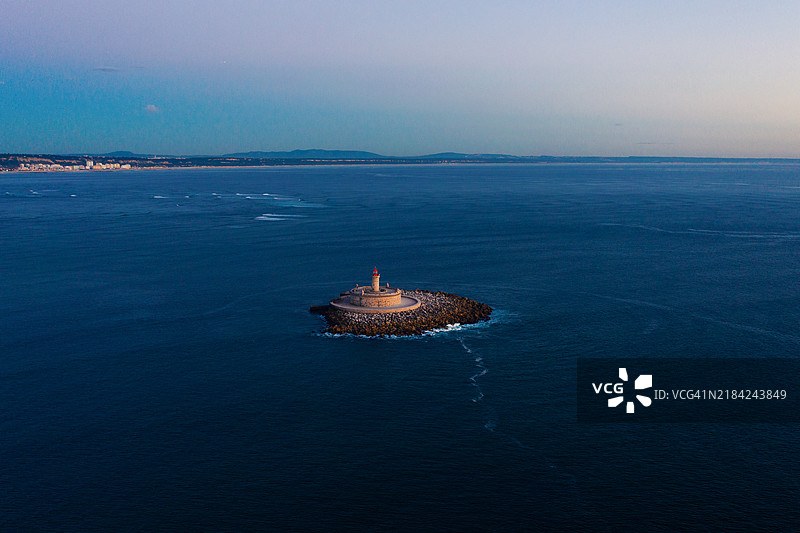 日落时分海洋中央的灯塔，航拍视角图片素材