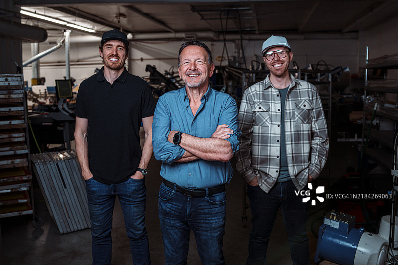 在制造厂与他的儿子们一起的企业家图片素材