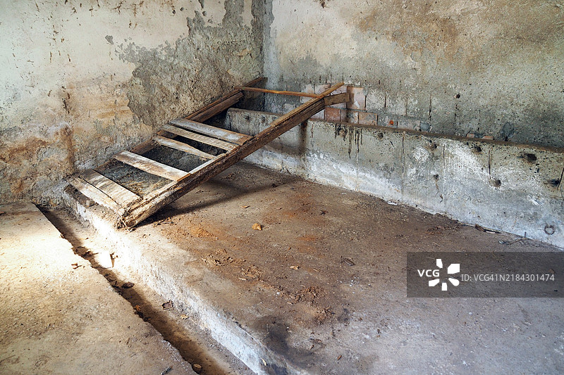 旧废弃的马厩，污迹斑斑的墙壁，石槽，破损的梯子图片素材