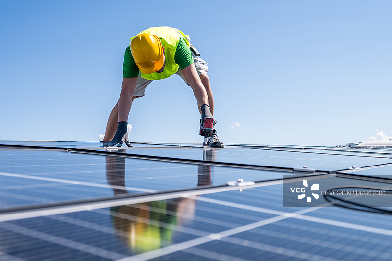 白人技术人员在屋顶安装太阳能电池板图片素材