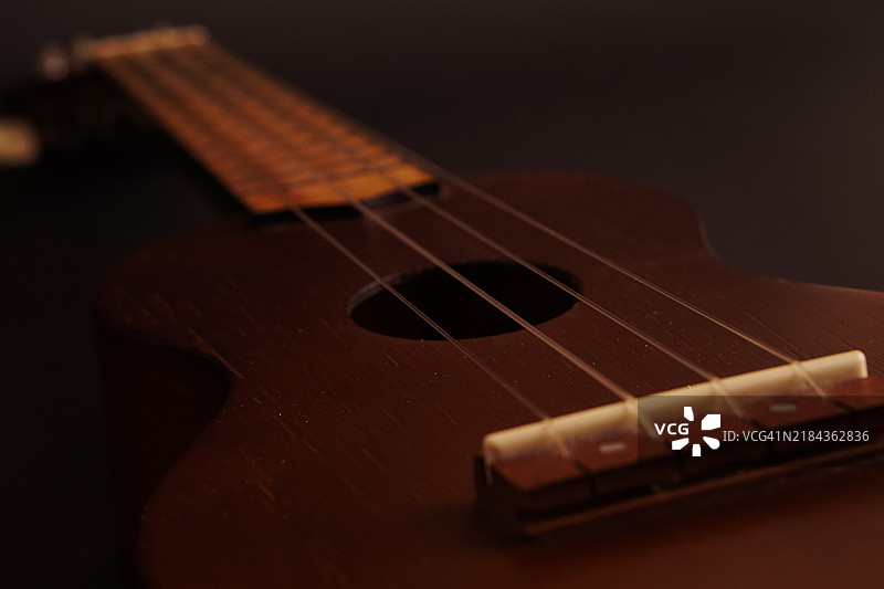 经典木制尤克里里特写在黑色背景上图片素材