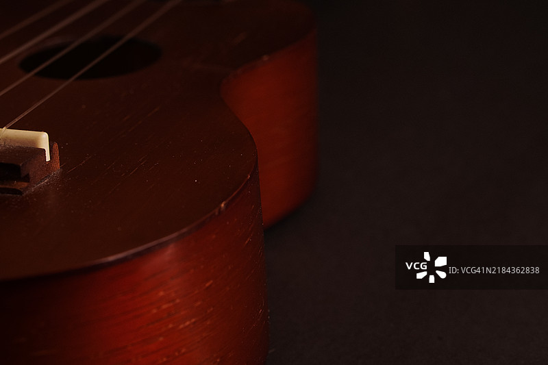 经典木制尤克里里特写在黑色背景上图片素材