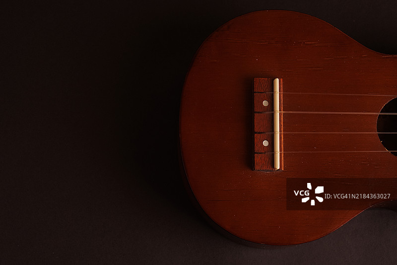 经典木制尤克里里特写在黑色背景上图片素材