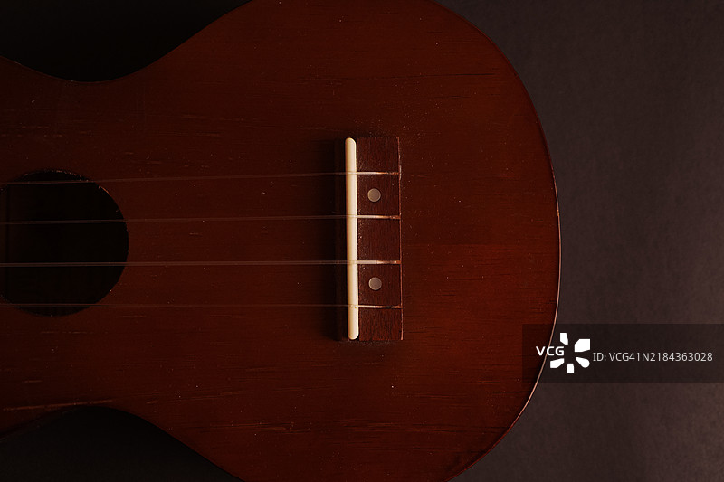 经典木制尤克里里特写在黑色背景上图片素材