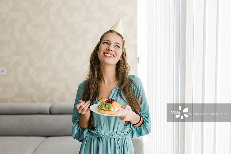 女人在家里吃一片甜蛋糕图片素材