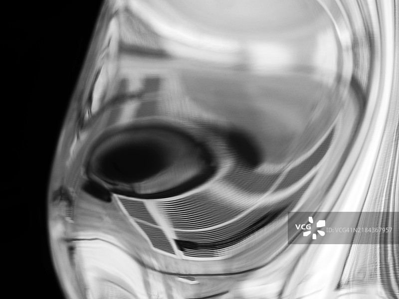 弯曲铝板的特写，上面反射着圆润的抽象形状。法国巴黎。自然光。单色。图片素材