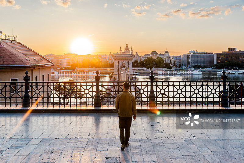 男子背影在日出时欣赏布达佩斯城市风景，匈牙利图片素材