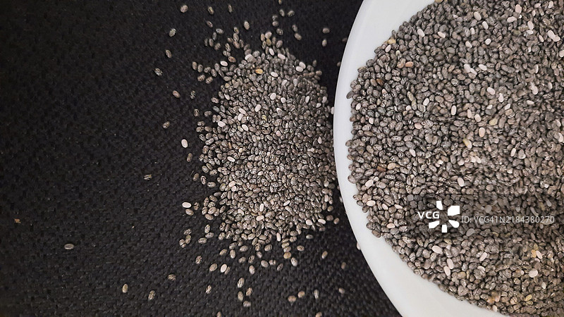 高角度视图的勺子里盛着奇亚籽，放在桌子上图片素材