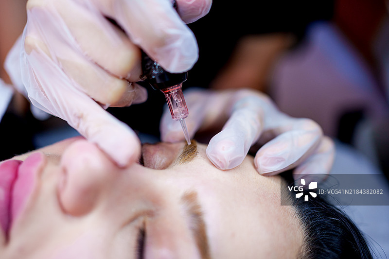 年轻女性接受持久化妆服务图片素材