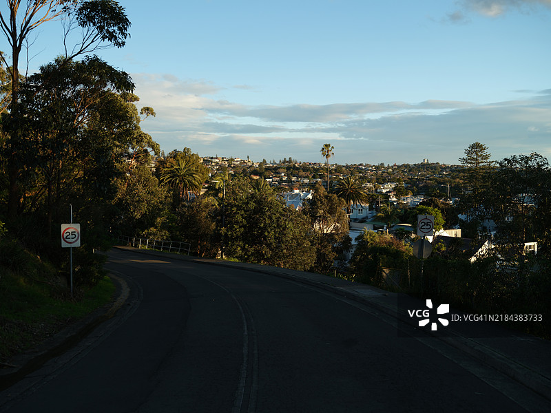 空旷的道路穿过树木，映衬着天空，澳大利亚图片素材