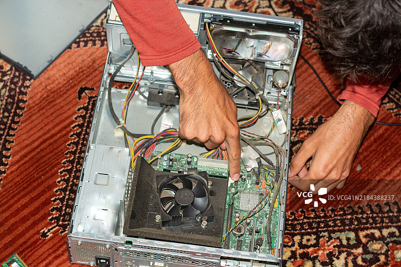 家庭修理工在家尝试修理他的电脑。图片素材