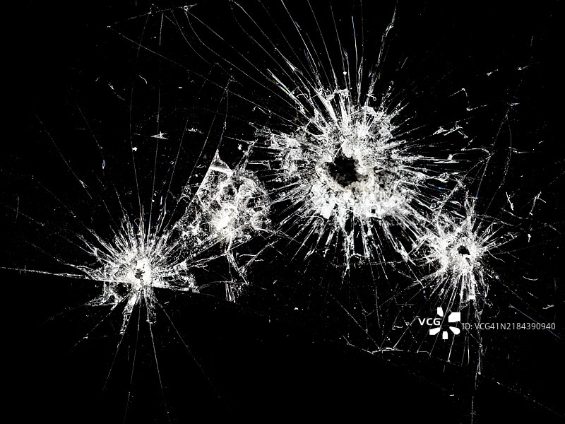 抽象背景，黑色玻璃上有撞击痕迹和子弹孔。图片素材