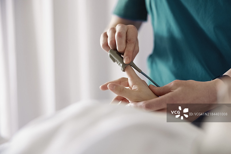 医疗专业人员正在为患者的手指放置脉搏血氧仪图片素材