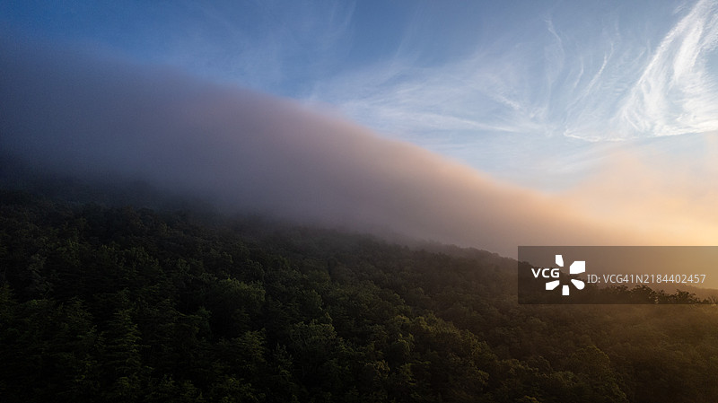 晨曦中雾气弥漫在山顶上图片素材