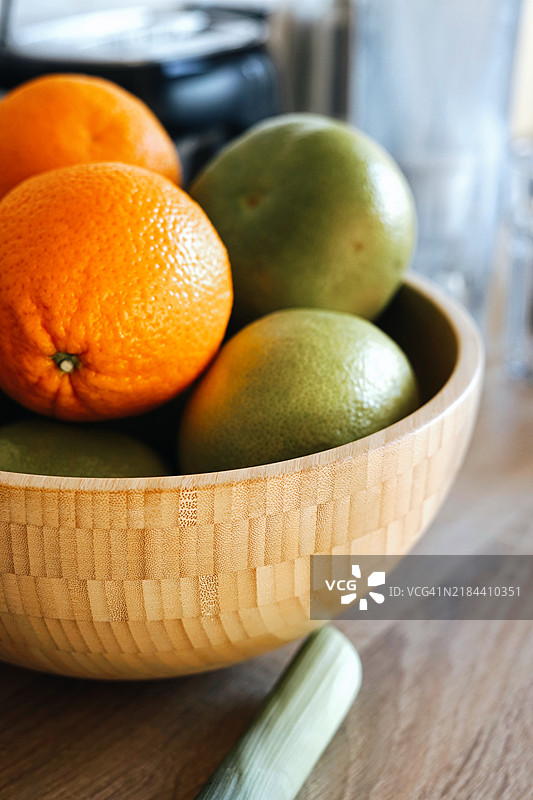 木碗里放着绿色葡萄柚和橙子，桌上健康的纤维和维生素C，增强免疫力。图片素材