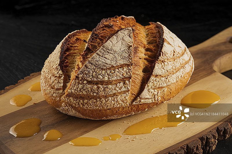 一张脆皮全谷物面包放在木板上的照片图片素材