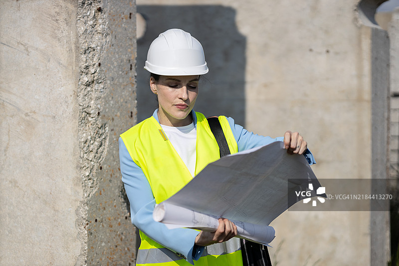女性建筑师在施工现场查看蓝图图片素材
