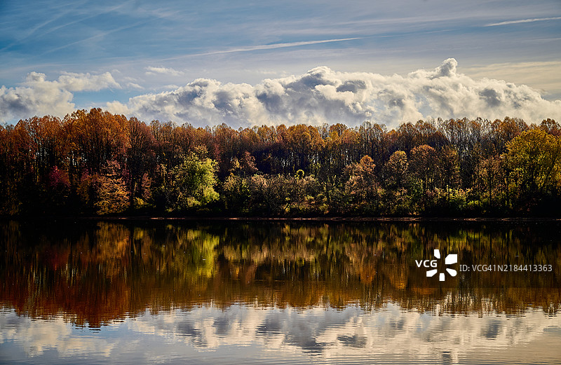秋天，宾夕法尼亚州朗霍恩湖边的树木与天空相映。图片素材