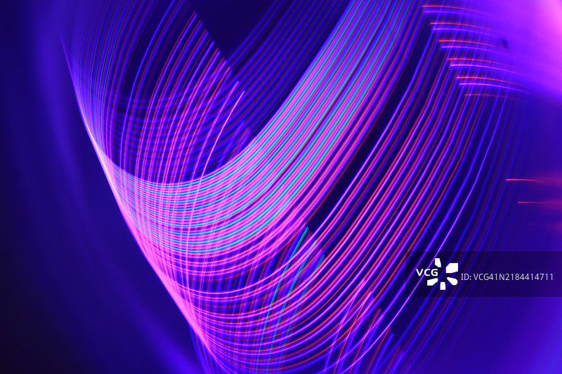 蓝色光轨在黑色背景上的特写图片素材