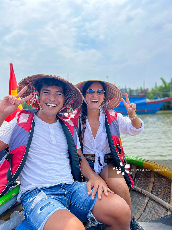 幸福的情侣在传统越南船上游玩图片素材