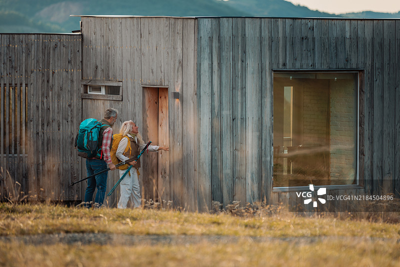 一对老年夫妇在徒步旅行后回家。图片素材