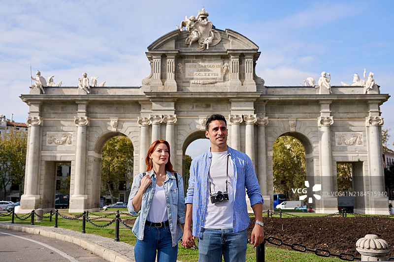 游客在西班牙马德里的阿尔卡拉门纪念碑前参观图片素材