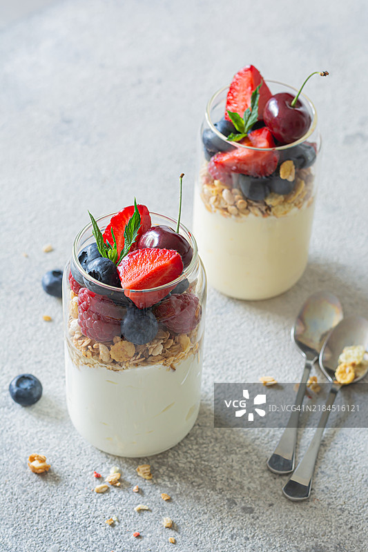 玻璃罐中的酸奶、格兰诺拉麦片和新鲜水果。健康的早餐，零食。外卖概念。图片素材