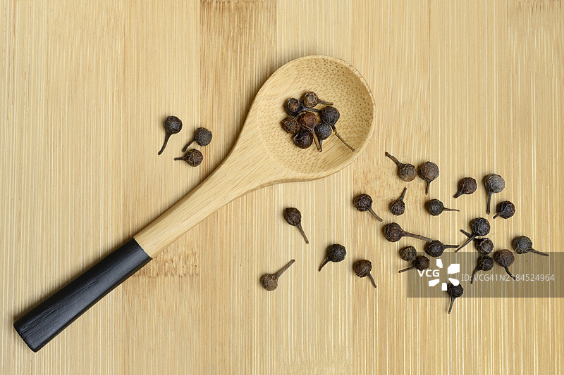 立方胡椒，木勺中的胡椒粒，胡椒属植物图片素材