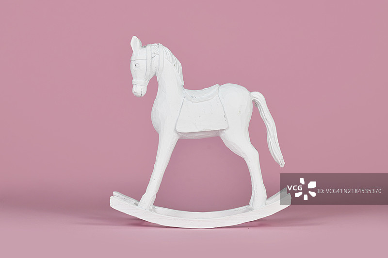 粉色背景上的白色复古风格摇马圣诞家居装饰物图片素材