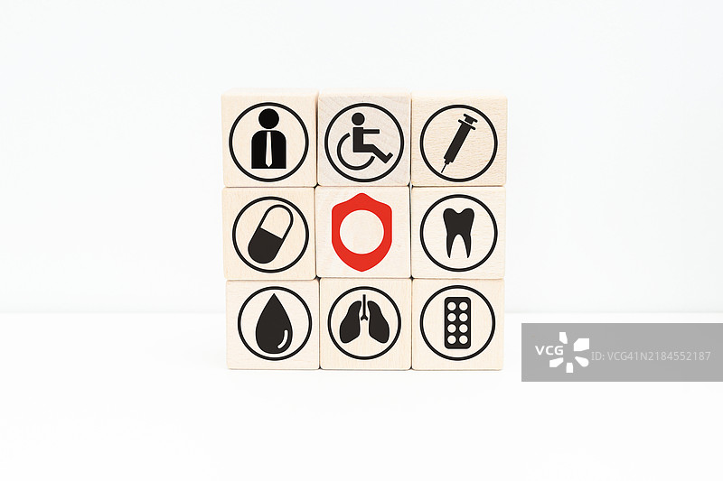堆叠的木块立方体，上面印有健康护理和医疗图标，体现健康与保健的概念图片素材