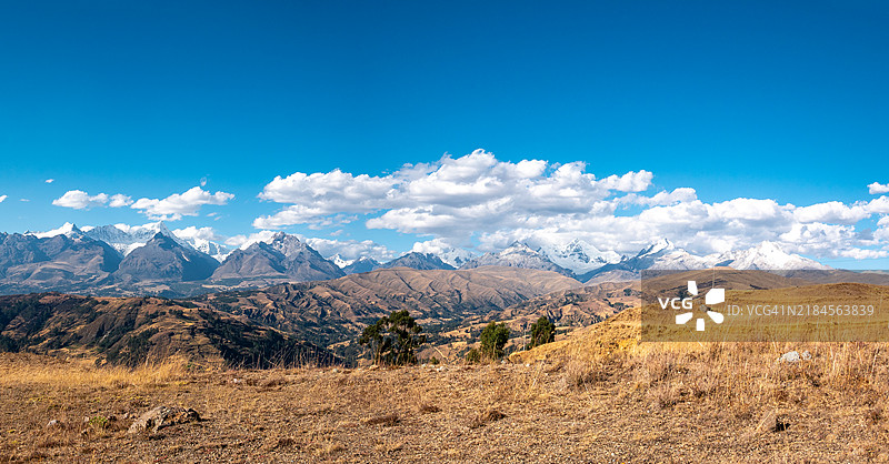 在秘鲁安卡什地区的华拉斯，阳光明媚的日子里，白色山脉的景色和周围的云朵。图片素材