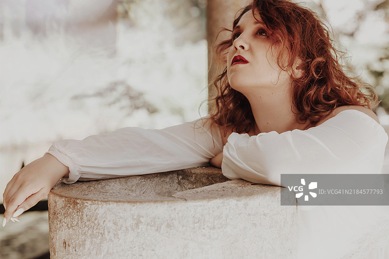 年轻的红发女性肖像，仰望着，面露痛苦之色图片素材